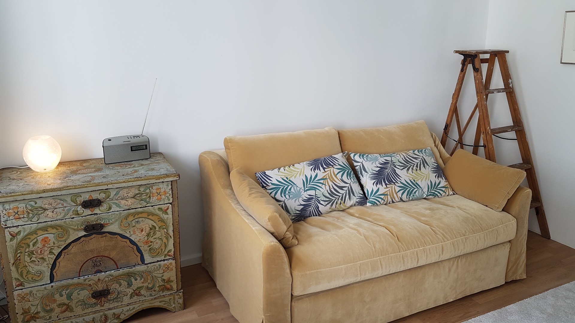 Sofaen kan raskt bli en god seng, 140 cm bred. I den rosemalte kommoden oppbevarer jeg mine egne ting. Den gamle stigen er eneste vei opp til hemsen...